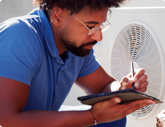 an hvac technician writing on a tablet